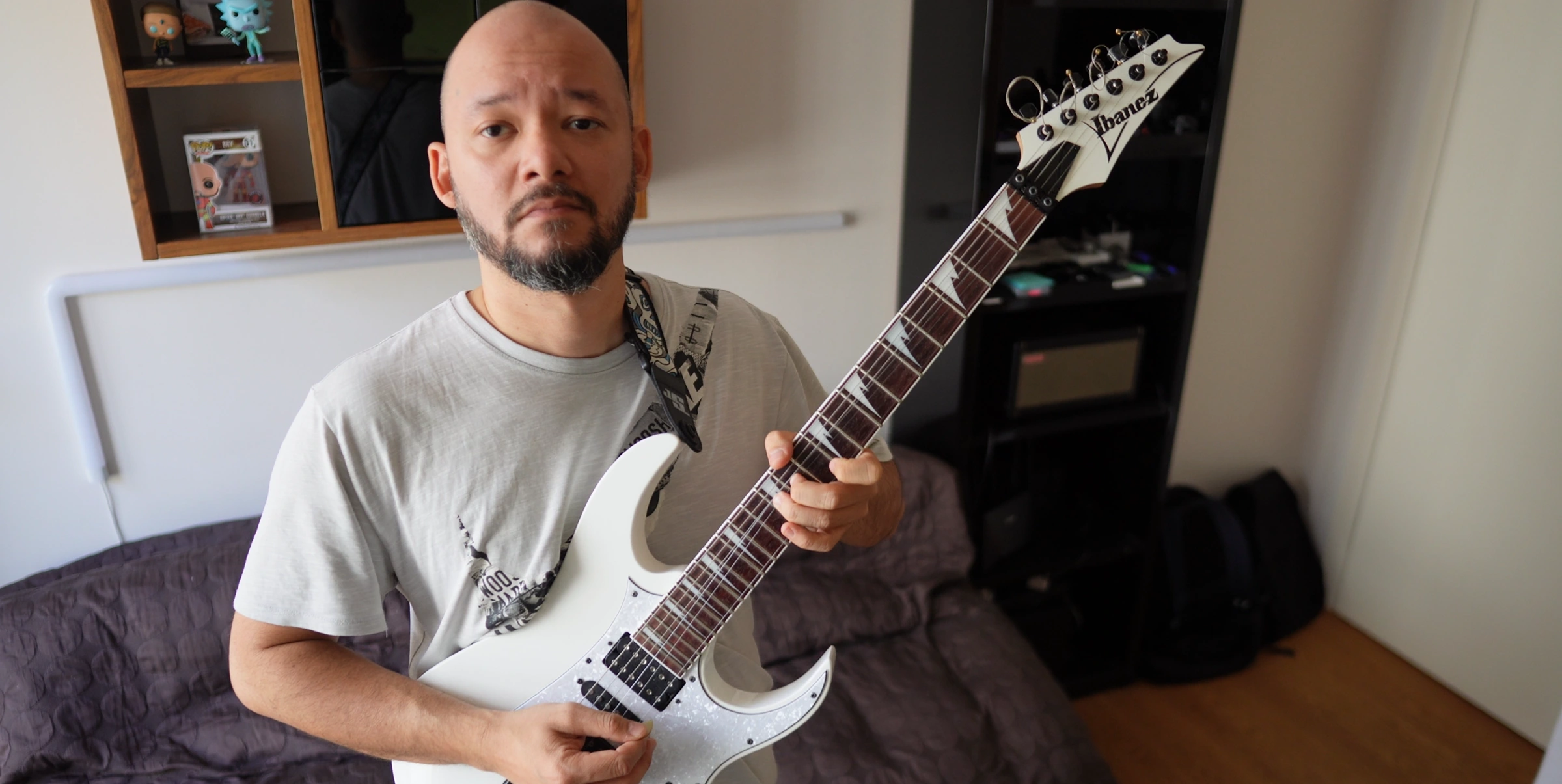 Bryan holding a white electric guitar